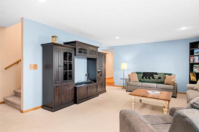 living area with stairway, light colored carpet, and baseboards