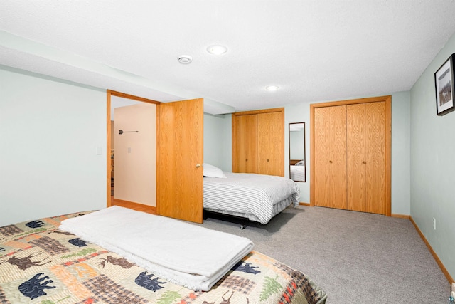 carpeted bedroom with recessed lighting and two closets