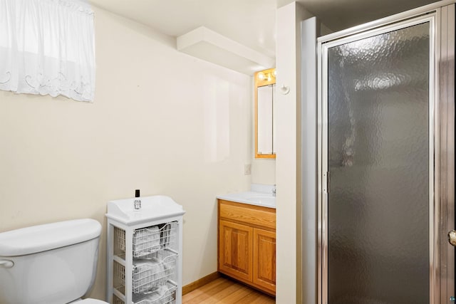 full bathroom with a shower stall, vanity, toilet, and wood finished floors