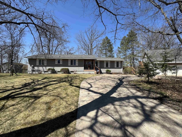 rear view of property featuring a yard and driveway