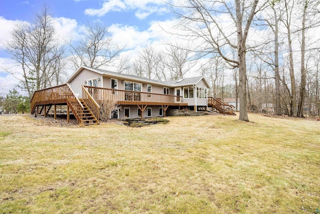 back of property with a lawn, a wooden deck, and stairs