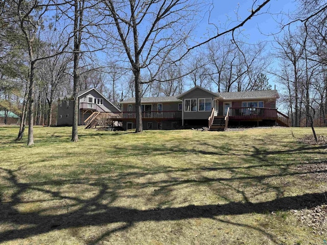 rear view of house with a yard, stairway, and a wooden deck