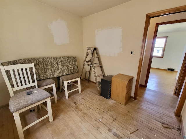 living area with baseboards, visible vents, and wood-type flooring
