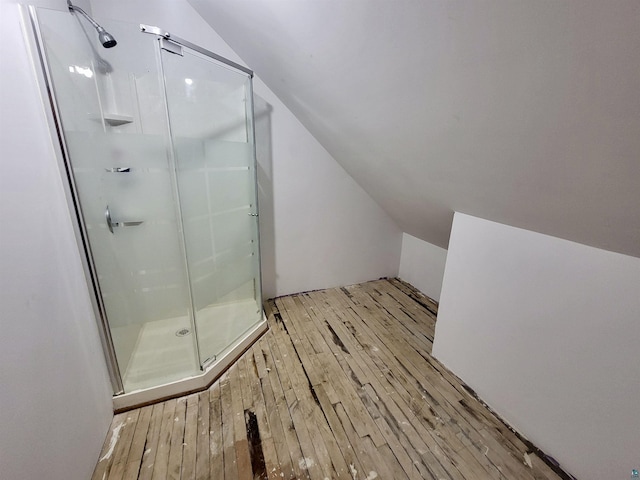 full bathroom with lofted ceiling, wood-type flooring, and a shower stall