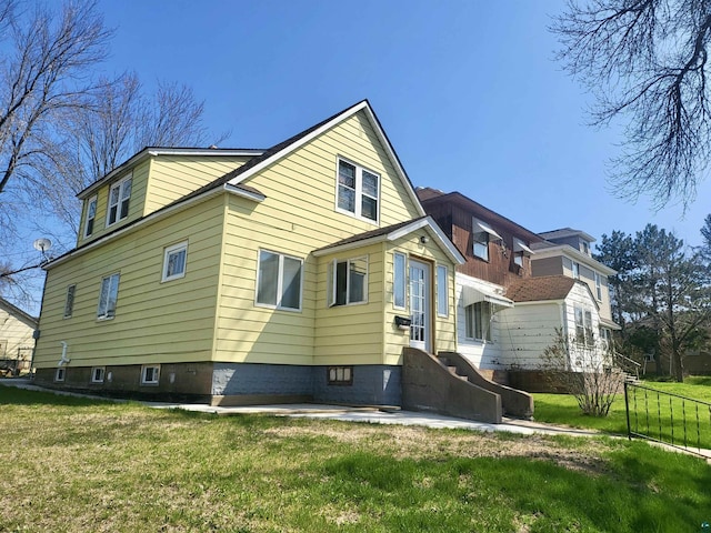 rear view of property with a lawn and fence