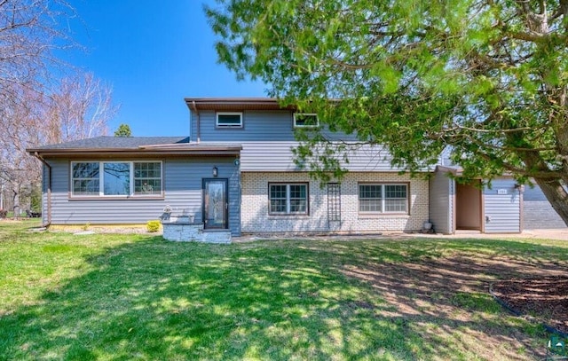 split level home featuring a front lawn and brick siding