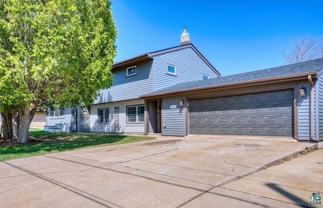 view of front of house featuring concrete driveway, an attached garage, and a chimney