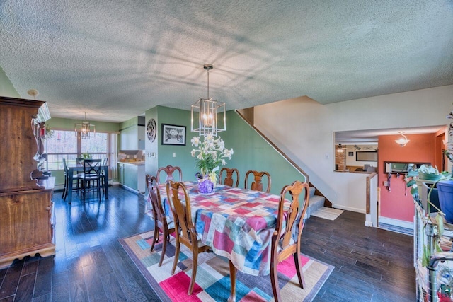 dining area with a textured ceiling, wood finished floors, baseboards, and a notable chandelier