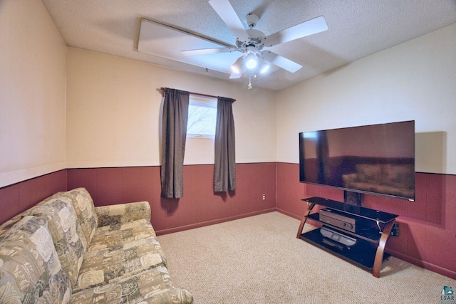 carpeted living area featuring a ceiling fan and a textured ceiling