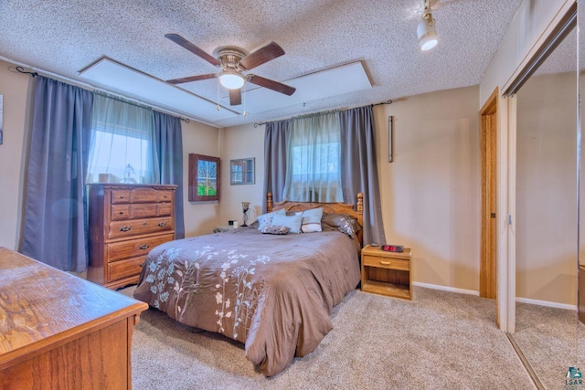 carpeted bedroom with multiple windows, a textured ceiling, baseboards, and ceiling fan