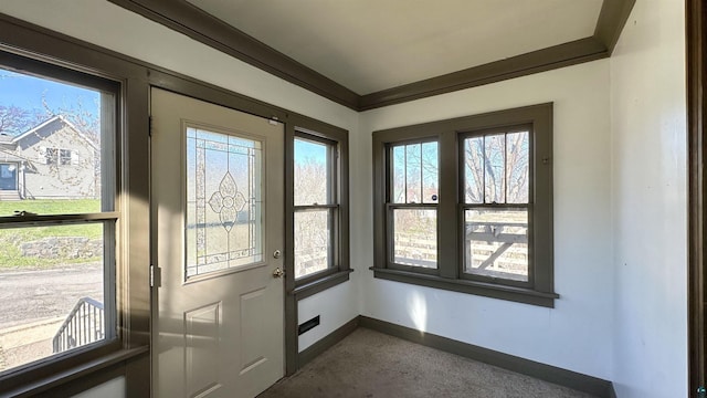 doorway featuring baseboards, dark colored carpet, and ornamental molding