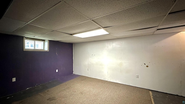 below grade area with a drop ceiling and carpet flooring