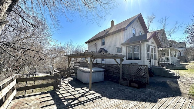 wooden deck featuring a hot tub and a pergola