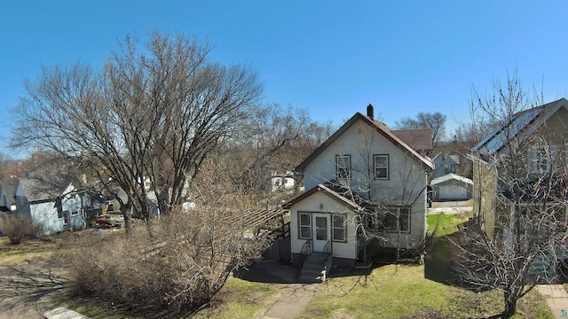 view of front of property with entry steps and a chimney