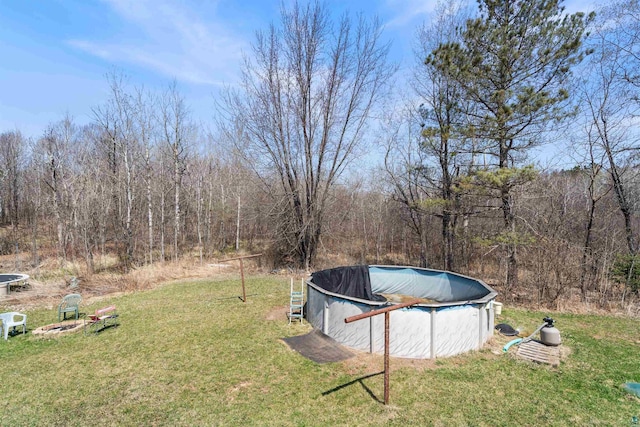 5463 Maple Hill Rd, Proctor, MN 55810 - view of grassy yard featuring a fire pit, a covered pool, and a forest view
