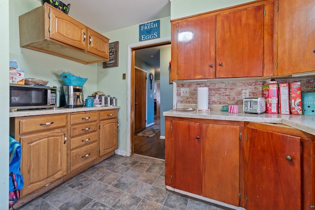 5463 Maple Hill Rd, Proctor, MN 55810 - kitchen with stainless steel microwave, light countertops, tasteful backsplash, stone finish flooring, and brown cabinets