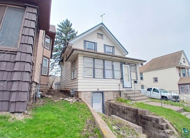 view of front of home featuring entry steps and a front yard