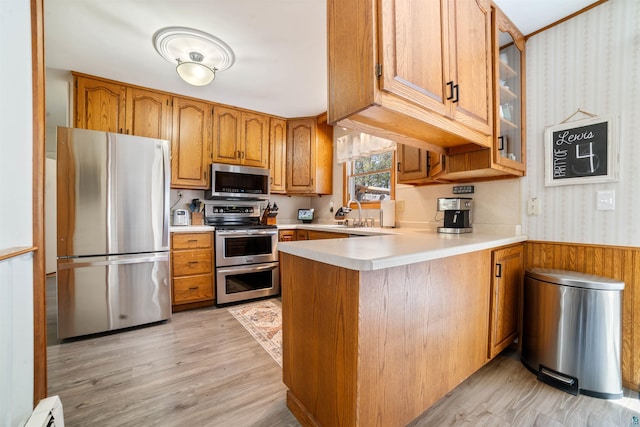 1741 Olsonville Crk, Carlton, MN 55718 - kitchen with appliances with stainless steel finishes, a peninsula, brown cabinets, wallpapered walls, and light countertops