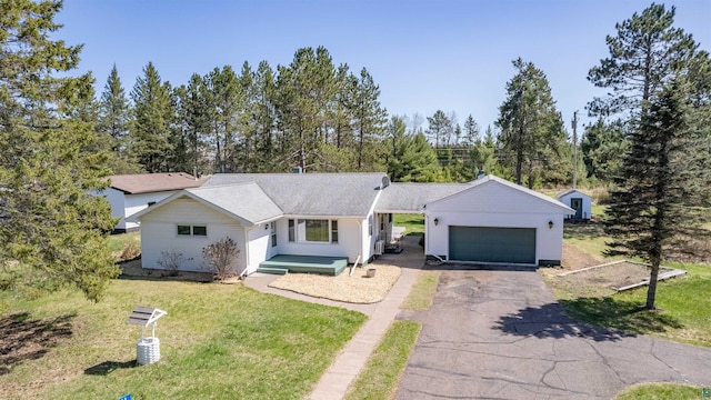 1741 Olsonville Crk, Carlton, MN 55718 - ranch-style home featuring a garage, a front lawn, asphalt driveway, roof with shingles, and view of wooded area