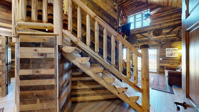 7498 Bayside Dr, Crane Lake, MN 55725 - stairs featuring wooden walls, plenty of natural light, wood finished floors, wood ceiling, and high vaulted ceiling