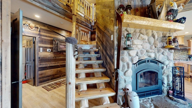 7498 Bayside Dr, Crane Lake, MN 55725 - stairs with wood finished floors, wooden walls, a fireplace, and recessed lighting