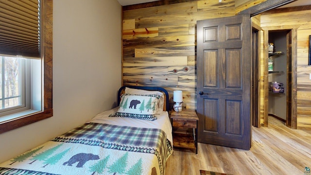 7498 Bayside Dr, Crane Lake, MN 55725 - bedroom with wooden walls and light wood-style flooring