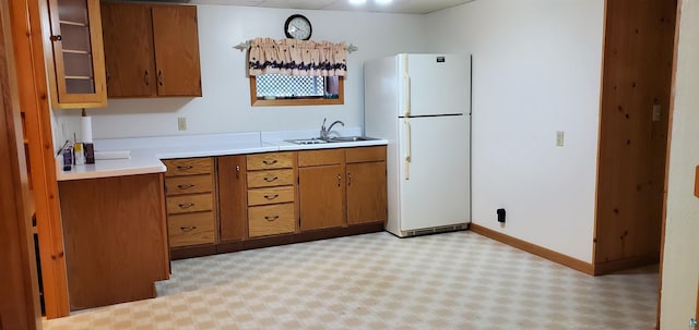 5729 Puncher Point Rd, Tower, MN 55790 - kitchen featuring freestanding refrigerator, brown cabinetry, light countertops, light flooring, and glass insert cabinets