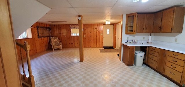 5729 Puncher Point Rd, Tower, MN 55790 - kitchen featuring brown cabinets, light countertops, wooden walls, open floor plan, and a drop ceiling