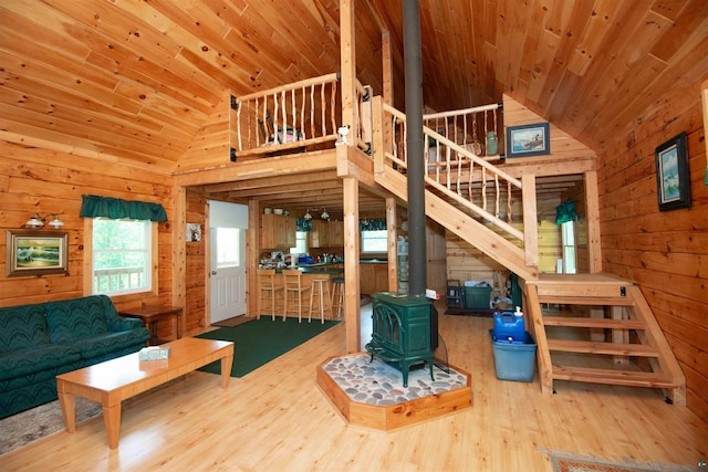 1808 Tom Lake Rd, Hovland, MN 55606 - living room featuring a wood stove, wood walls, wood finished floors, wood ceiling, and stairway