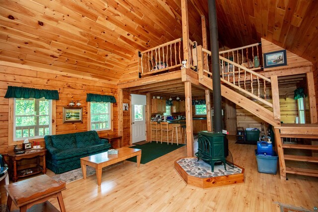 1808 Tom Lake Rd, Hovland, MN 55606 - living room with a wood stove, wooden walls, wood ceiling, wood finished floors, and stairway