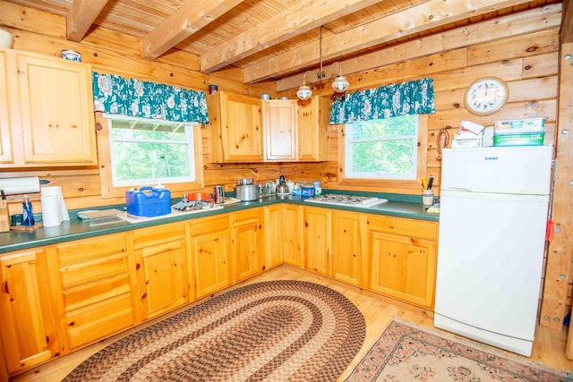 1808 Tom Lake Rd, Hovland, MN 55606 - kitchen with freestanding refrigerator, plenty of natural light, dark countertops, beam ceiling, and light brown cabinetry