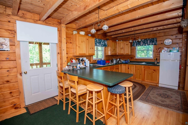 1808 Tom Lake Rd, Hovland, MN 55606 - kitchen with freestanding refrigerator, dark countertops, plenty of natural light, beamed ceiling, and a peninsula