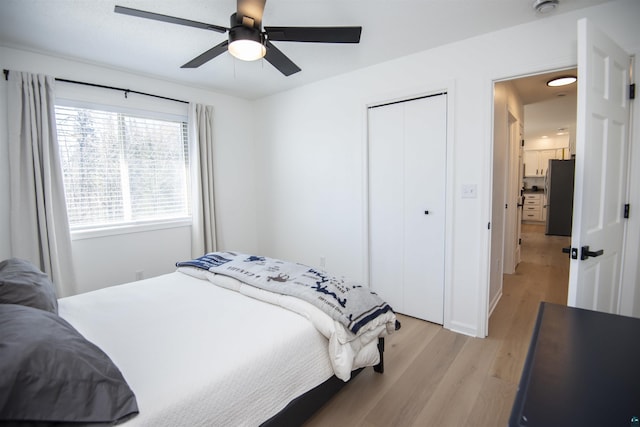 500 W 5th St, Grand Marais, MN 55604 - bedroom featuring freestanding refrigerator, light wood-style flooring, a closet, and ceiling fan