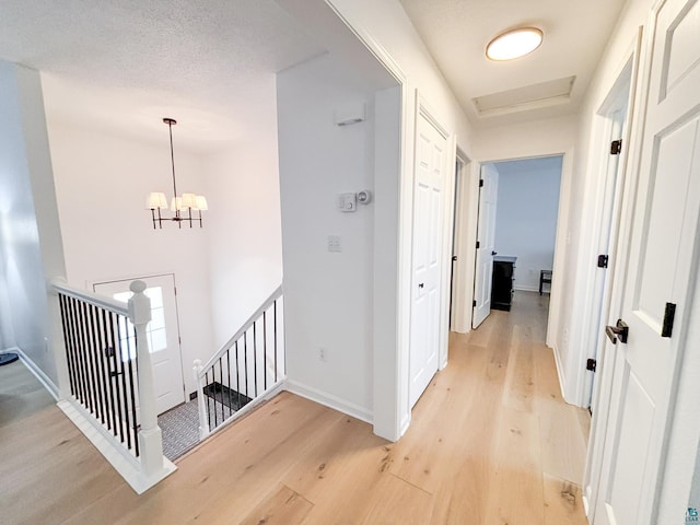 500 W 5th St, Grand Marais, MN 55604 - hallway featuring an upstairs landing, light wood finished floors, baseboards, and a chandelier