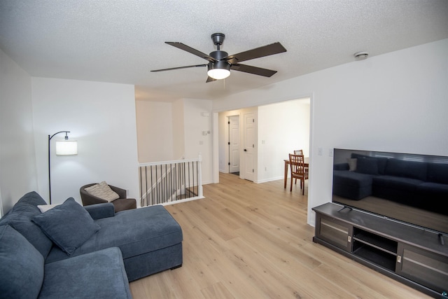 500 W 5th St, Grand Marais, MN 55604 - living room featuring light wood-type flooring, a ceiling fan, a textured ceiling, and baseboards