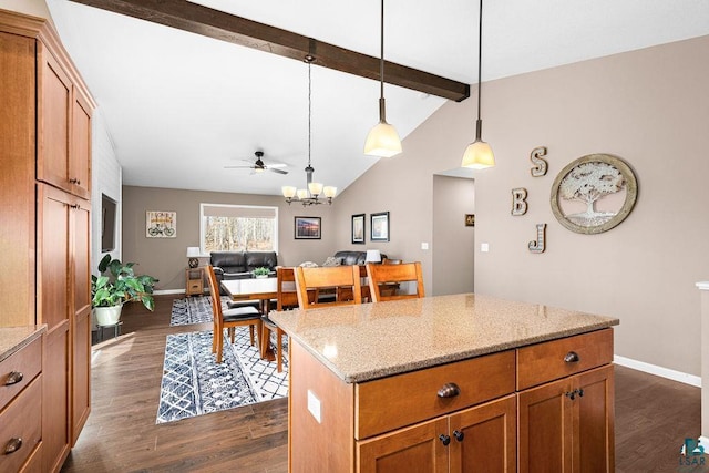 kitchen featuring dark wood-style flooring, decorative light fixtures, light stone counters, brown cabinetry, and baseboards