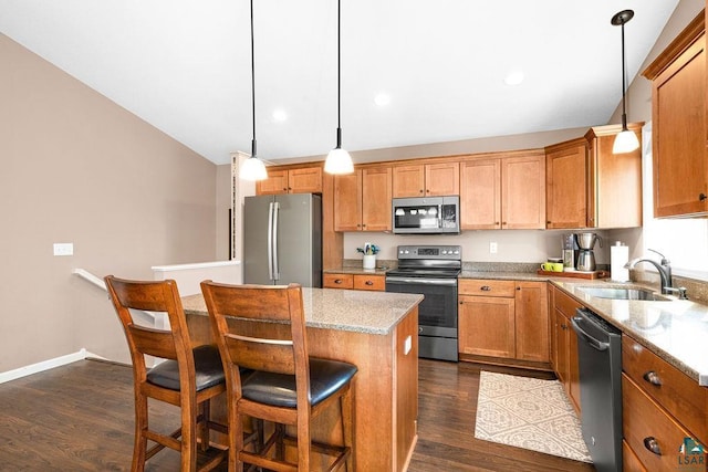 kitchen featuring stainless steel appliances, a kitchen breakfast bar, a kitchen island, dark wood-type flooring, and lofted ceiling