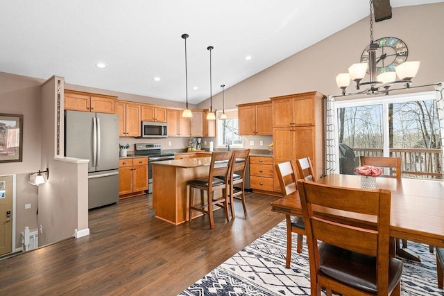 dining space featuring dark wood-type flooring, a chandelier, recessed lighting, and high vaulted ceiling
