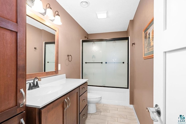 full bathroom featuring toilet, vanity, enclosed tub / shower combo, and baseboards