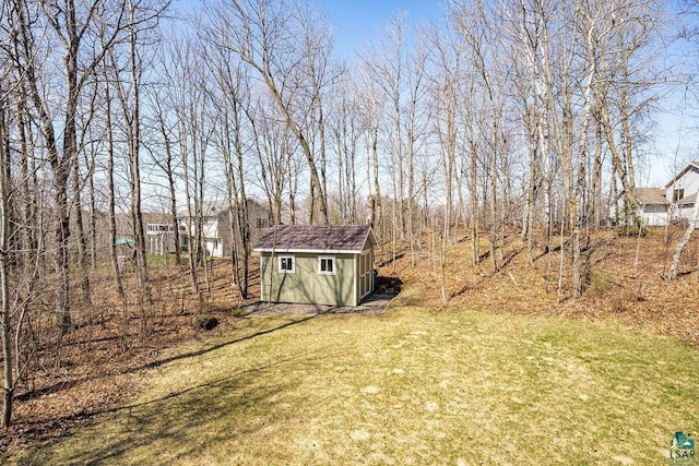 view of green lawn with a storage shed and an outdoor structure