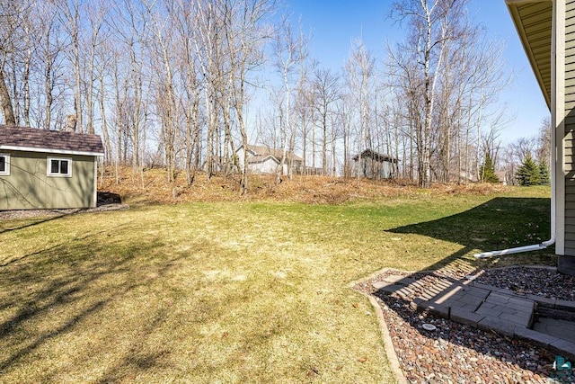 view of grassy yard with an outbuilding and a storage unit