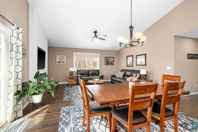 dining space with lofted ceiling, baseboards, a chandelier, a ceiling fan, and dark wood-style flooring