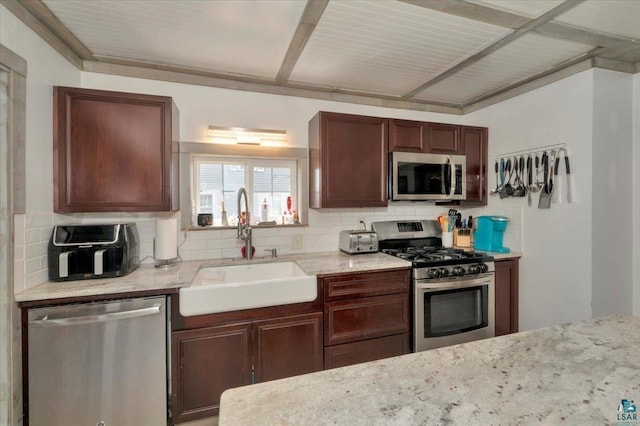 121 11th St, Cloquet, MN 55720 - kitchen with appliances with stainless steel finishes, a sink, tasteful backsplash, and light stone counters