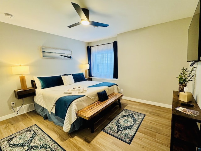 bedroom featuring wood finished floors, baseboards, and ceiling fan
