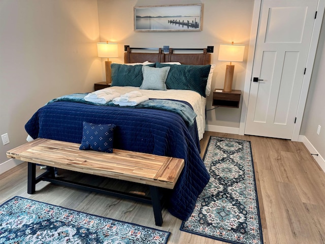 bedroom with baseboards and wood finished floors