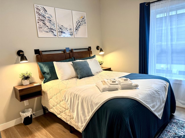 bedroom with wood finished floors and baseboards