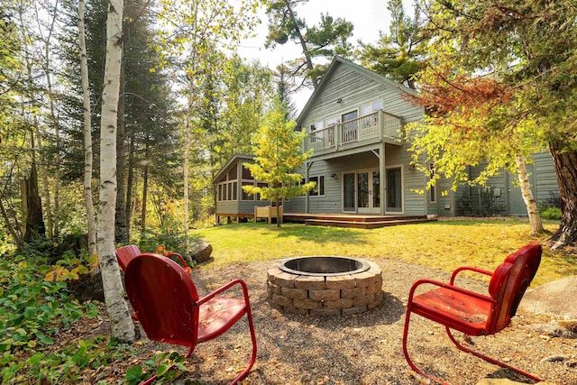 879 Clearwater Rd, Grand Marais, MN 55604 - view of green lawn featuring french doors, an outdoor fire pit, a balcony, and a sunroom