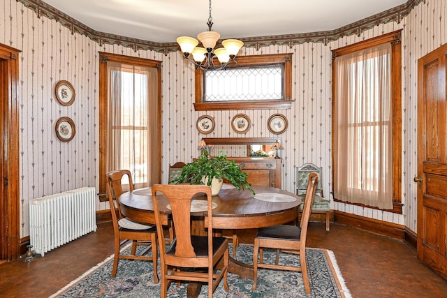 dining area with radiator heating unit, finished concrete flooring, a chandelier, baseboards, and wallpapered walls