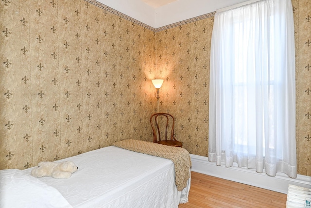 bedroom featuring hardwood / wood-style flooring and wallpapered walls