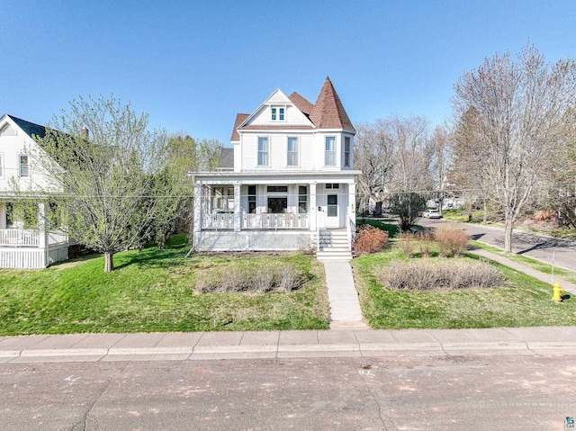 victorian house featuring a porch and a front lawn